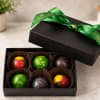 Box of assorted chocolates with a green ribbon on the lid