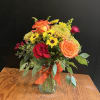 Bouquet of orange and red roses with yellow daisies in a glass vase