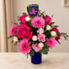 Pink roses and gerbera daisies in a blue vase with a police patch pick