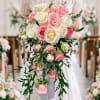 A romantic cascading bridal bouquet featuring soft blush and ivory roses, accented