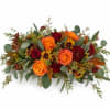 Low floral arrangement with orange and red roses and autumn mums