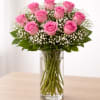 Pink roses arranged in a clear glass vase with white filler flowers
