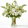 White lilies and roses arranged in a clear glass vase