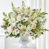 White floral arrangement in a white vase with lilies, roses, and daisies