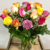 Mixed-color roses in a clear glass vase with baby's breath