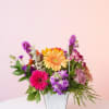 Colorful mixed flower arrangement in a white vase