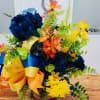 Colorful floral arrangement with blue, yellow, and orange blooms in a vase