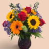 Mixed bouquet of sunflowers, red roses, and orange gerbera daisies in a dark vase