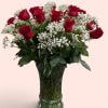 Red roses and white baby's breath in a clear glass vase