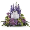 Purple floral arrangement around a white urn