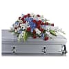 Red, white, and blue floral spray on a silver casket