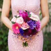 Woman holding a bouquet of pink, purple, and white flowers
