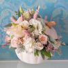 Pastel floral arrangement in a white pumpkin-shaped container