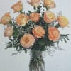 Arrangement of peach roses with white filler flowers in a clear glass vase