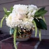 White rose and chrysanthemum arrangement in a woven vase