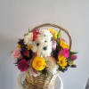 Puppy in a basket with bright color flowers to cheer up anybody.