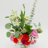 Mixed bouquet of roses and white lilies in a clear glass vase