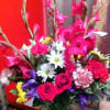 Bright mixed bouquet with pink roses and white daisies in a glass vase