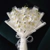 White orchid bouquet wrapped in white paper with a ribbon bow