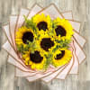 Bouquet of sunflowers wrapped in pale pink paper