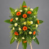 Standing floral spray with orange gerbera daisies and pale yellow carnations