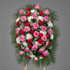 Standing floral wreath with pink roses, red carnations, and white chrysanthemums