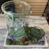 Glass fountain display with purple flowers and butterfly accents on a tray
