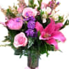 Pink and purple mixed bouquet in a glass vase with a ribbon