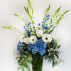 Blue and white floral arrangement in a tall glass vase