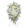 Standing floral spray with white and light blue flowers on a black easel
