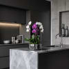 Potted orchid arrangement with white and purple blooms in a metal container