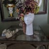 Floral headpiece on a white mannequin bust with purple and cream roses