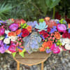 Colorful floral arrangement with roses and succulents in a wooden container