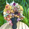 Large bouquet of dried roses and hydrangeas in a black vase