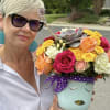 Woman holding a colorful bouquet in a painted face vase