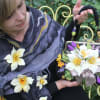 Woman holding a floral handbag decorated with white and purple flowers