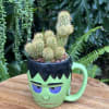 Small cactus arrangement in a Frankenstein face mug