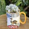 Small cactus in a patterned mug planter