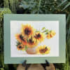 Framed sunflower artwork on an easel