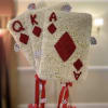 Floral arrangement shaped like playing cards with red suit symbols