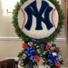 Large floral tribute shaped like a baseball with a Yankees logo