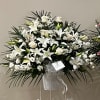 White lilies and roses in a standing spray with a ribboned easel