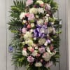 Large standing floral spray with pink, white, and purple blooms
