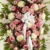 Standing floral spray of pink and white flowers with a white ribbon