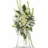 Tall white and pale yellow funeral spray on a stand