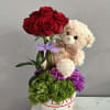 Red roses with a teddy bear in a heart-decorated pot