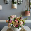 Mixed pastel flower arrangement in a white ribbed vase
