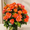 Orange roses arranged in a clear glass vase