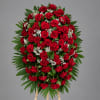 Standing spray of red roses with white baby's breath on an easel