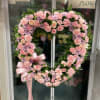 Heart-shaped floral wreath with pink roses, carnations, and lavender mums